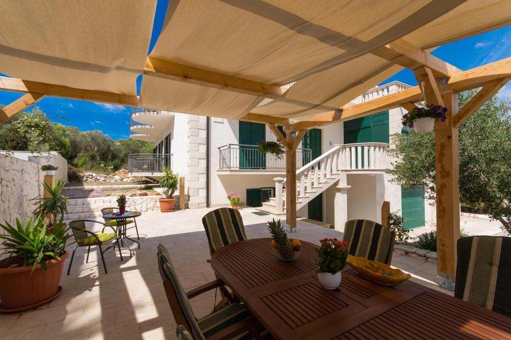 Shaded terrace with dining table at Guesthouse Vakans